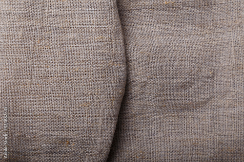 Sackcloth texture of folded grey fabric, background or backdrop.