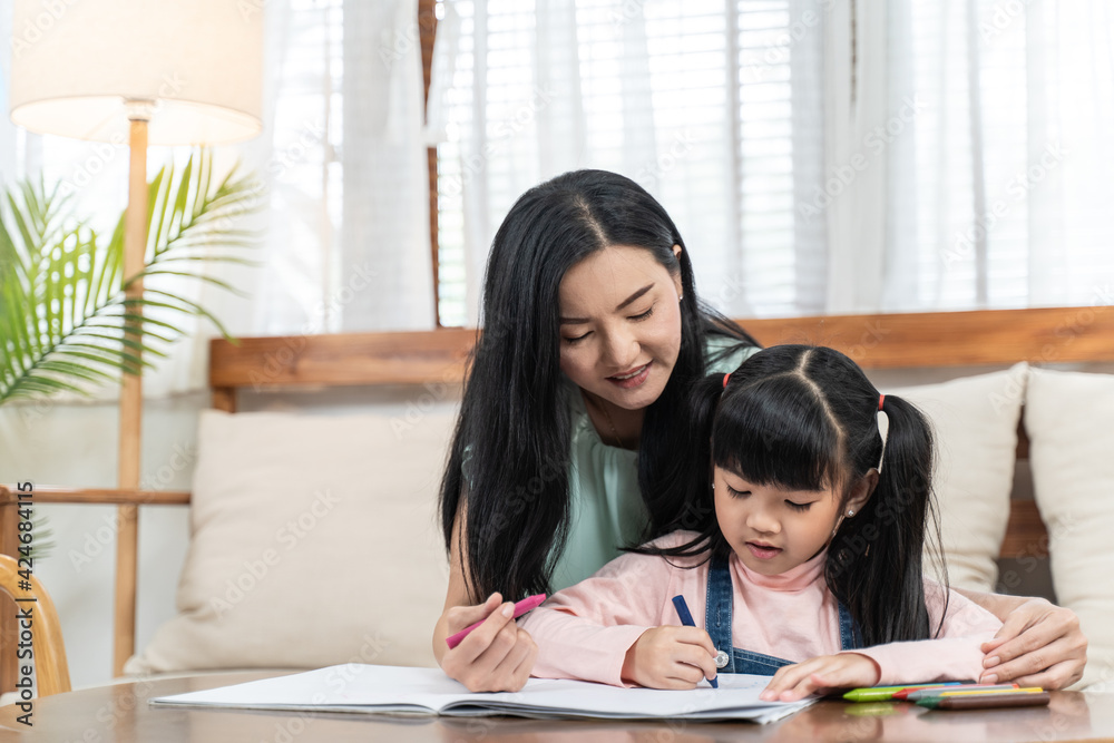 Asian girl drawing and painting picture with mother in the living room Asian girl drawing and painting picture with mother in the living room