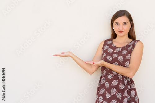 Portrait of beautiful woman outdoors showing copy space againt plain wall