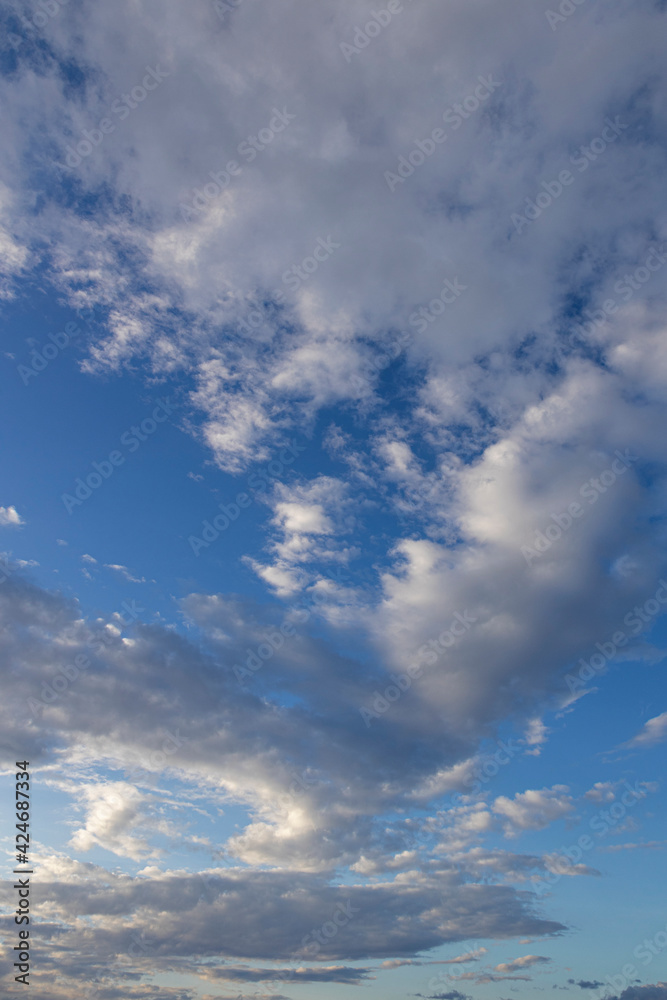 Clouds in the blue sky. Vertical layout of the image. Contrasting clouds. Clouds in the blue sky. Vertical layout of the image. Contrasting clouds.
