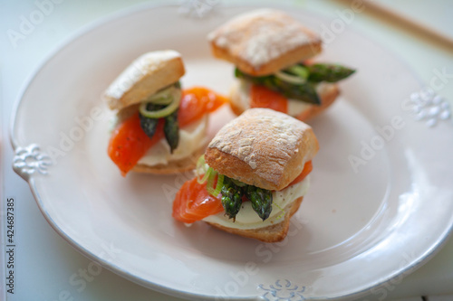 Mini sándwich de salmón y espárrago con mahonesa sobre fondo blanco. Salmon and asparagus mini sandwich with mayonnaise on white background.