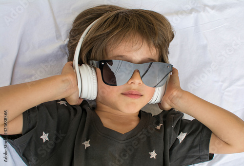 Cute Young Boy Listening To Music Wearing Headphones. Close-up Of A Beautiful Relaxed Child Listening To Music.