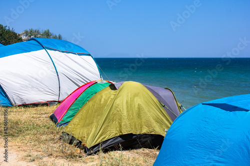Tents on the shores of the turquoise sea during the day