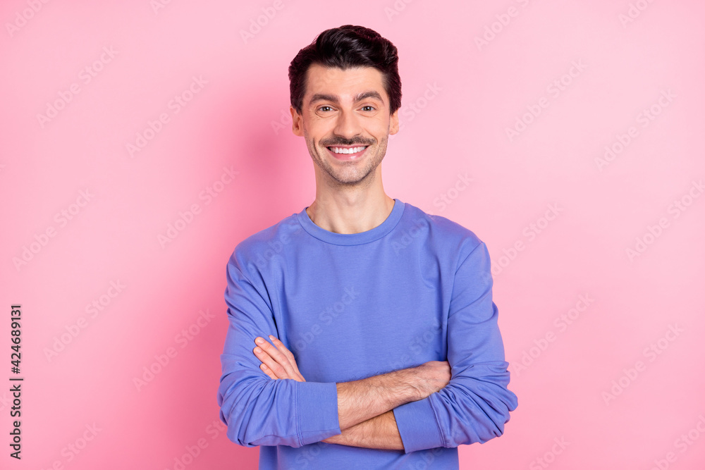 Photo of cheerful confident young man hold hands folded smile rest isolated on pink color background Photo of cheerful confident young man hold hands folded smile rest isolated on pink color background