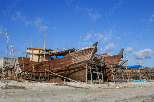 Landscape view of Bugis traditional shipyard with wooden phinisi boats in Tanah Beru, Bulukumba, South Sulawesi, Indonesia photo