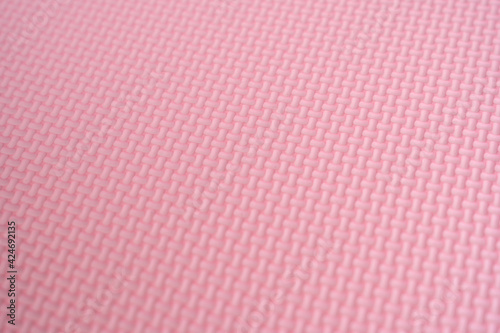 The surface of the pink foam rubber floor tiles. Selective focus