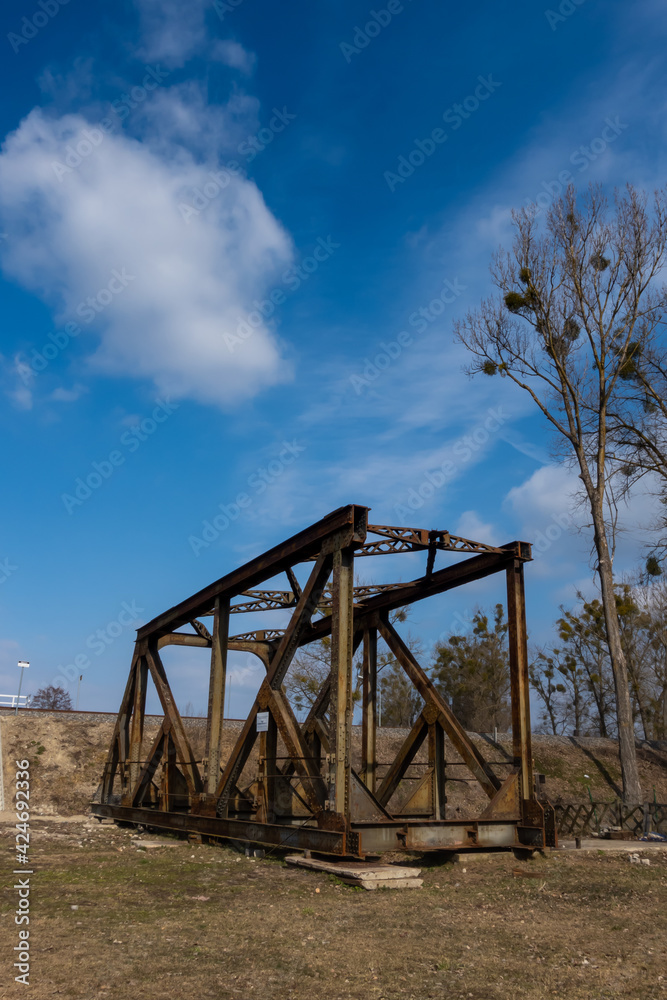Rusty spans of the old railway bridge have been dismantled. Perspective photo taken on a sunny day. Rusty spans of the old railway bridge have been dismantled. Perspective photo taken on a sunny day.