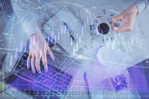 Multi exposure of man's hands typing over computer keyboard and forex graph hologram drawing. Top view. Financial markets concept.