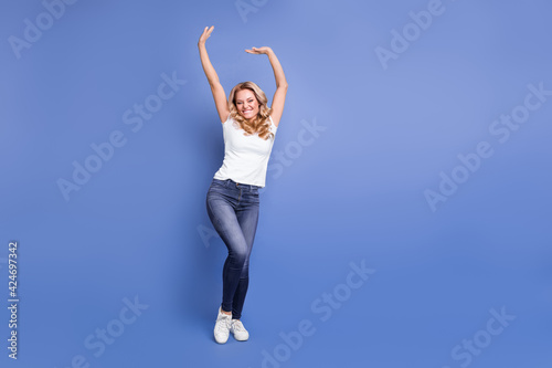 Full length body size view of attractive cheerful glad wavy-haired girl dancing having fun isolated over blue color background