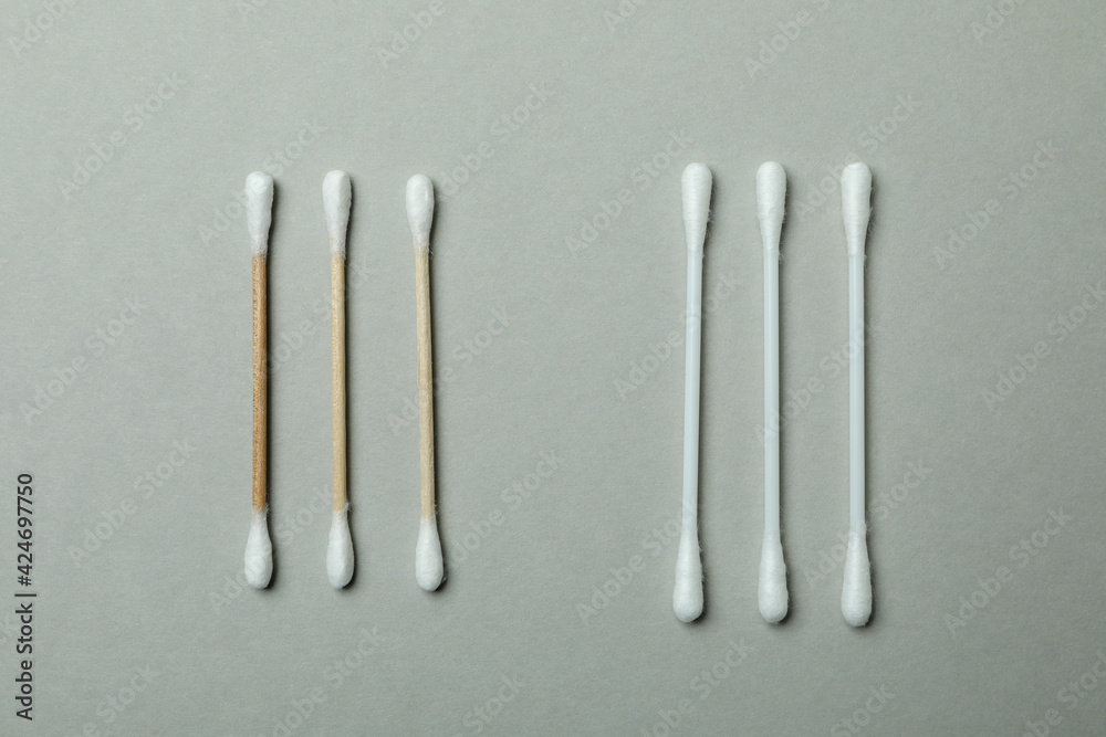 Wooden and plastic cotton swabs on light gray background Wooden and plastic cotton swabs on light gray background