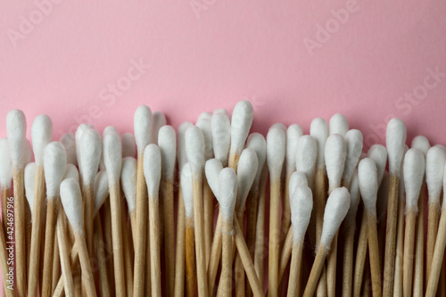 Cotton swabs on pink background  space for text