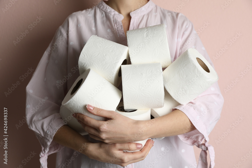 Woman with heap of toilet paper rolls on pink background, closeup Woman with heap of toilet paper rolls on pink background, closeup