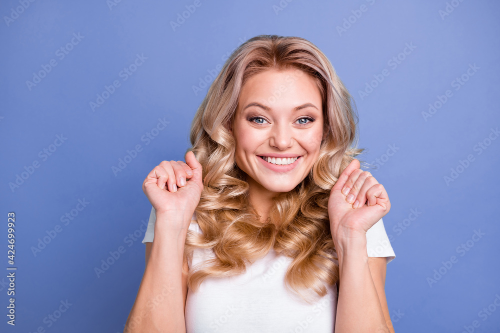 Photo of young happy excited amazed cheerful girl hold fists in victory win in lottery isolated on blue color background Photo of young happy excited amazed cheerful girl hold fists in victory win in lottery isolated on blue color background