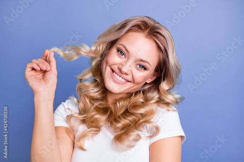 Photo of young pretty charming positive smiling girl happy after hair treatment isolated on blue color background