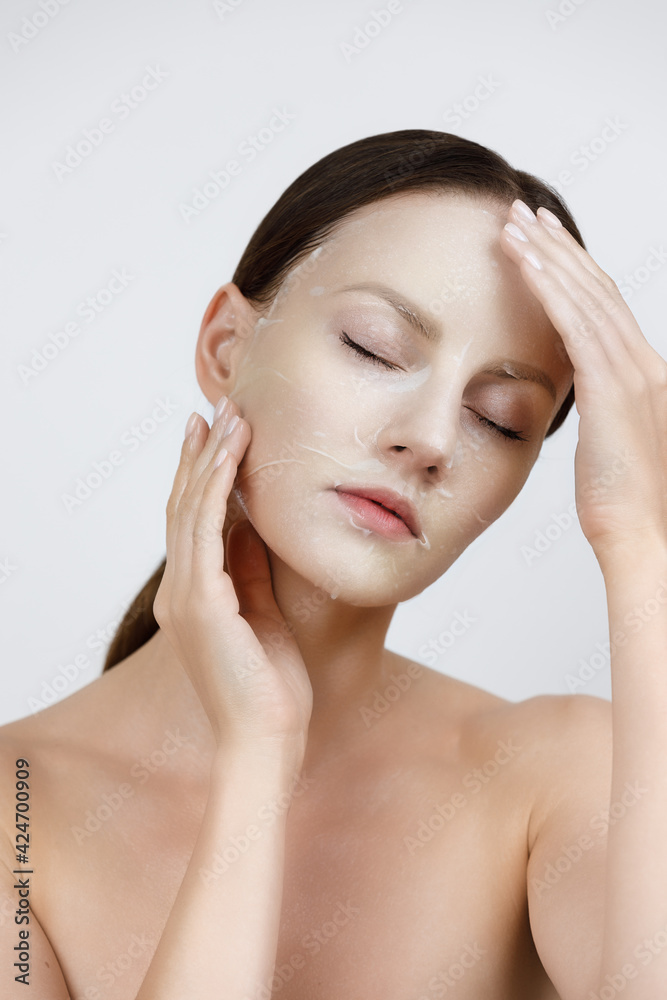 Face Skin Care moisturizing Korean cosmetics concept. Portrait Of Beautiful woman applying and smoothing White Sheet Mask Face Skin Care moisturizing Korean cosmetics concept. Portrait Of Beautiful woman applying and smoothing White Sheet Mask