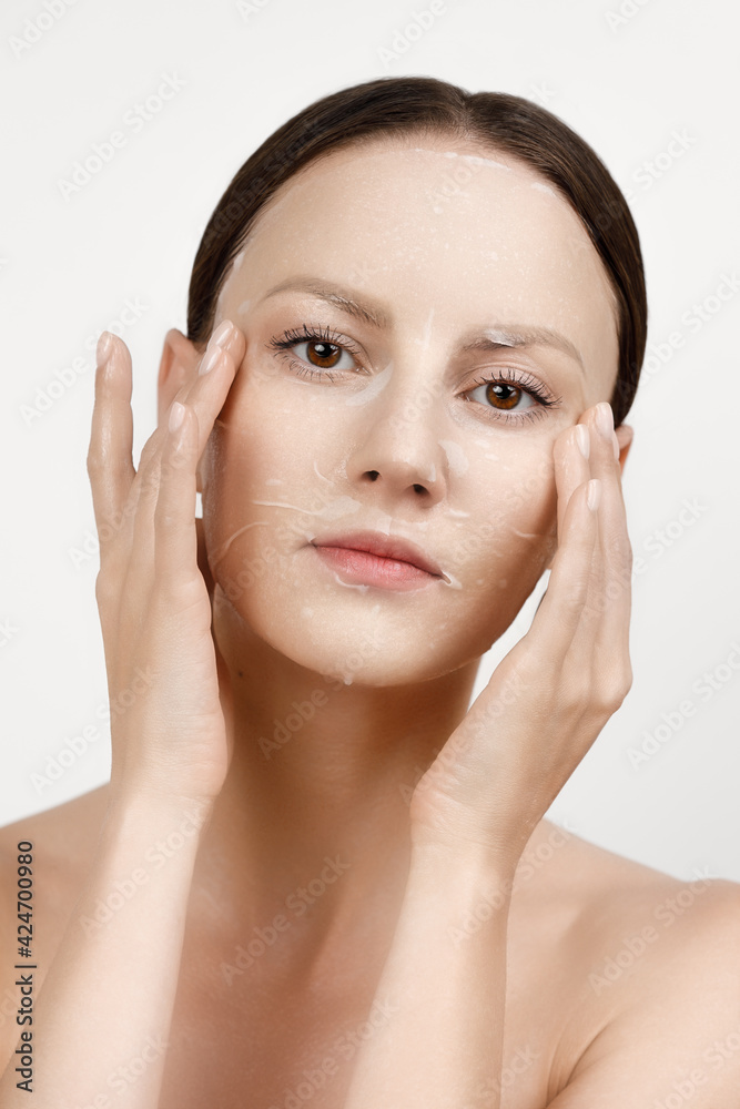 Face Skin Care moisturizing Korean cosmetics concept. Portrait Of Beautiful woman applying and smoothing White Sheet Mask Face Skin Care moisturizing Korean cosmetics concept. Portrait Of Beautiful woman applying and smoothing White Sheet Mask