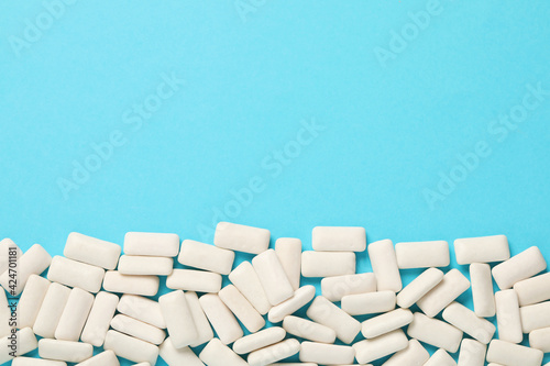 Obraz na plátně Many chewing gum pieces on light blue background, flat lay
