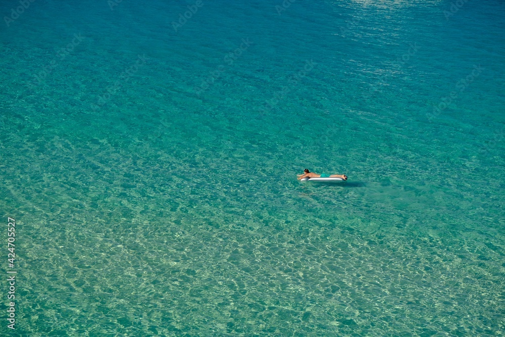 Chalkidiki, Greece - August 14, 2017 : One person enjoying the crystal clear turquoise waters in Chalkidiki Greece