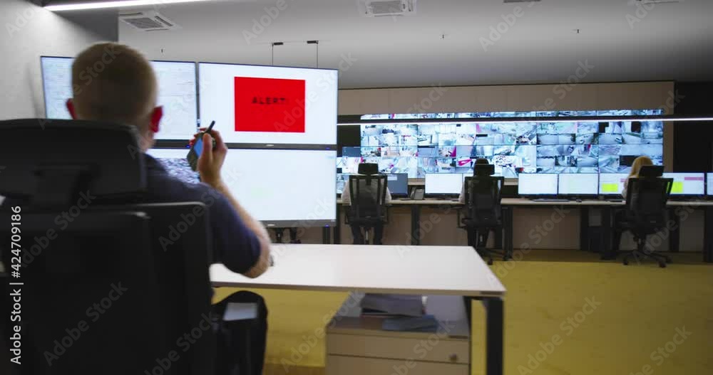 Security guards watching video monitoring surveillance security system im modern facility with high end protection systems and technology