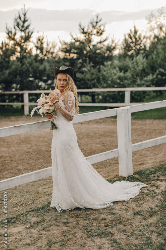 Portrait of the bride. A beautiful woman in white wedding dress in bohemian style. Sunset