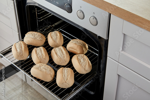 Bread buns in modern oven in kitchen