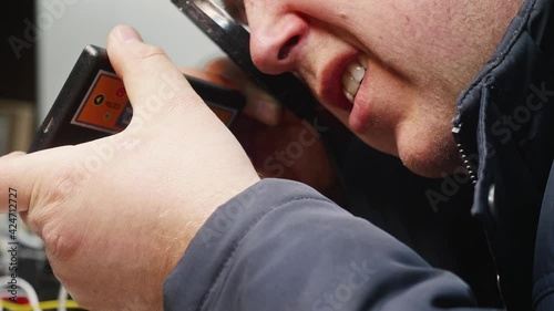 Close up of man face expamining broken device using loupe. Repairing euqipment. photo