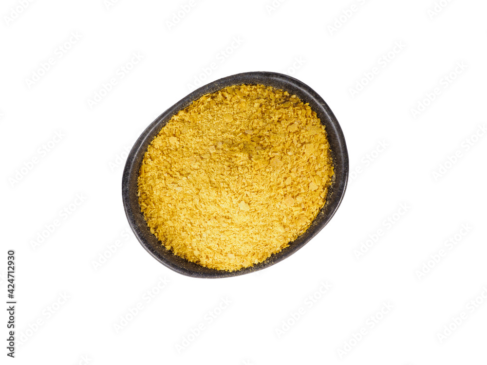 Nutritional yeast in black bowl isolated on white background. Nutritional yeast in black bowl isolated on white background.