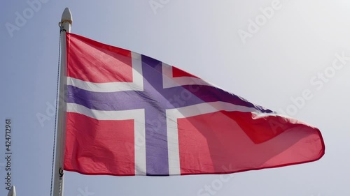 Flag of Norway fluttering against blue sky in slow motion photo