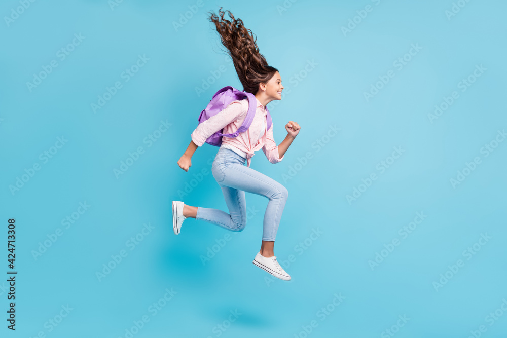 Full size profile side photo of young happy smiling cheerful girl with brown hair jump isolated on blue color background