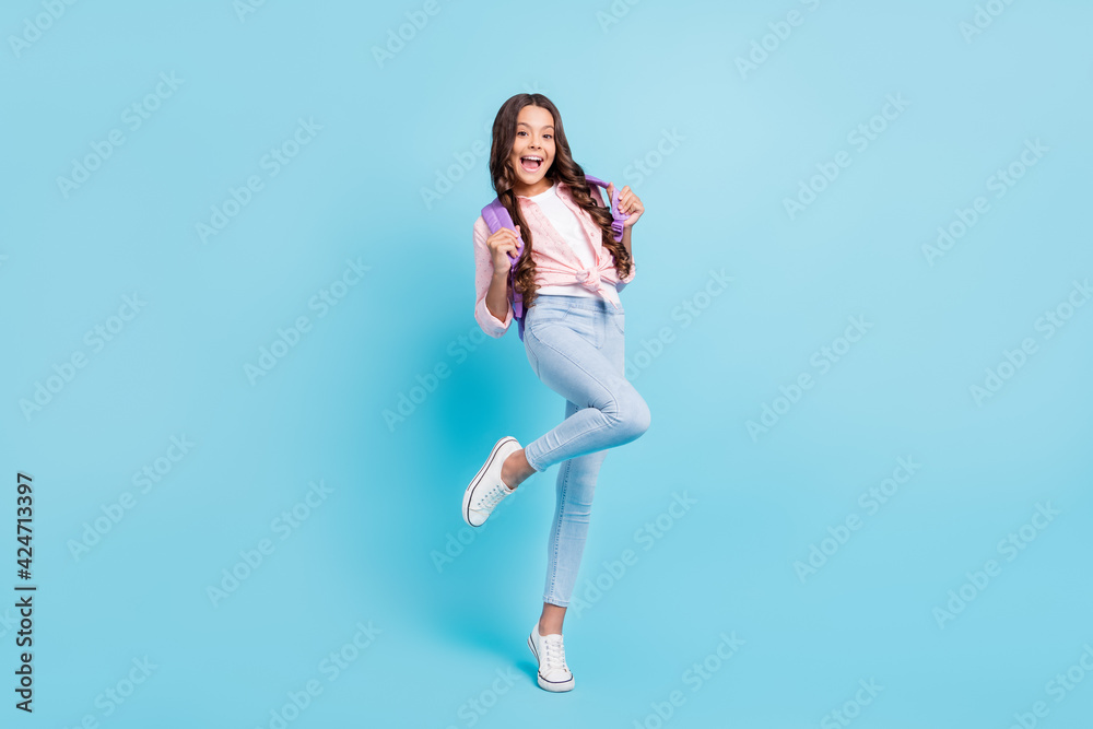 Full size photo of young happy excited funky positive good mood schoolgirl wear violet bag isolated on blue color background Full size photo of young happy excited funky positive good mood schoolgirl wear violet bag isolated on blue color background
