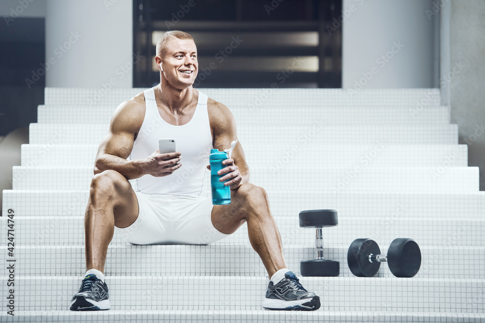 Fit man at workout in gym with cell phone Fit man at workout in gym with cell phone
