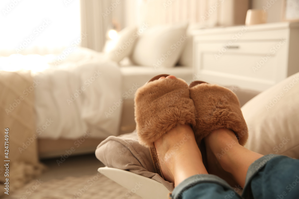 Woman wearing soft comfortable slippers at home, closeup. Space for text - obrazy, fototapety, plakaty 