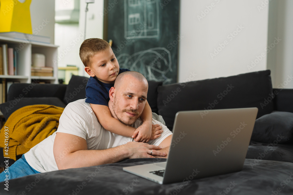 father and son using laptop computer at home. they are relaxing sofa father and son using laptop computer at home. they are relaxing sofa