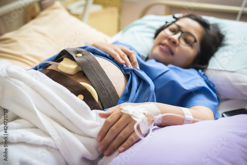 The expectant mother is wearing a stethoscope to prepare the baby for the caesarean section.