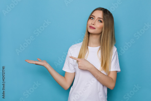 Beautiful Young Woman Is Presenting Something And Pointing