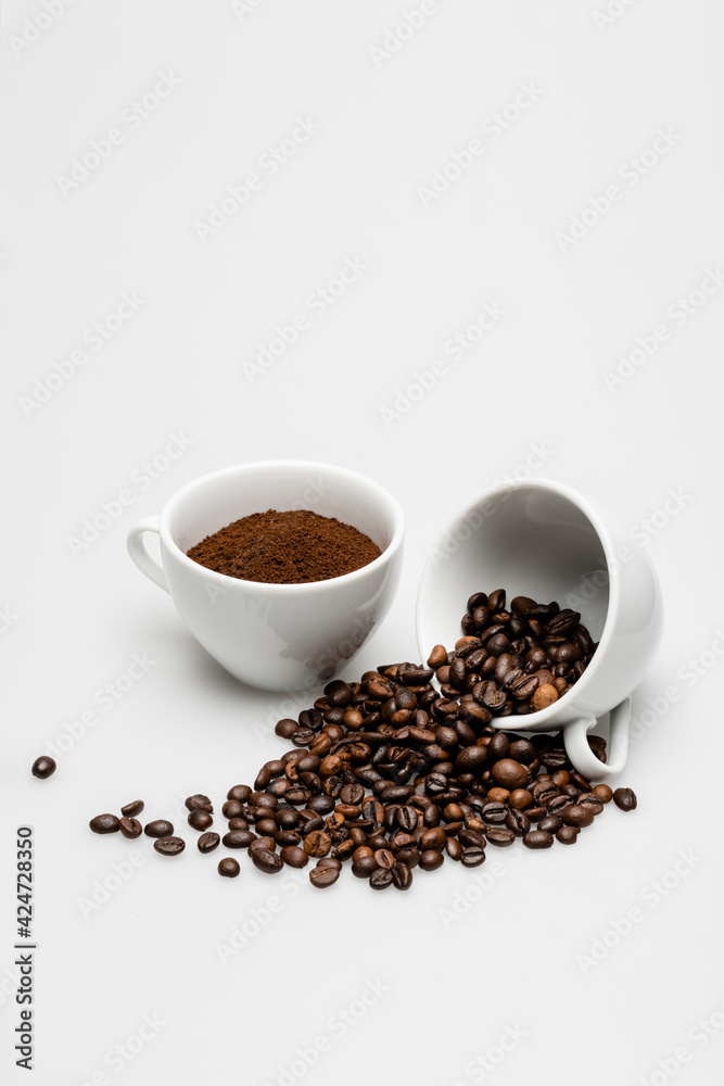 beans and ground coffee in mugs on white beans and ground coffee in mugs on white