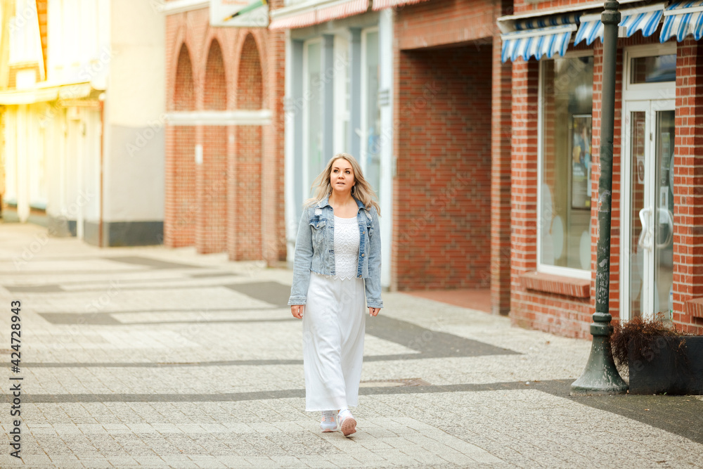 Young woman is walking downtown. Spring mood in the city. Tourist on vacation in a European city 