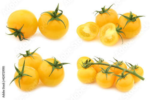 fresh yellow "tasty tom" tomatoes on the vine on a white background