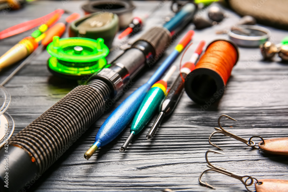 Different fishing equipment on dark wooden background, closeup Different fishing equipment on dark wooden background, closeup