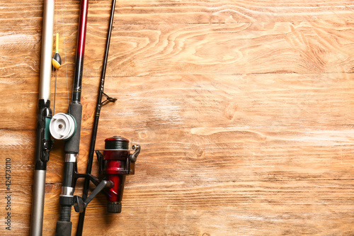 Different fishing rods on wooden background