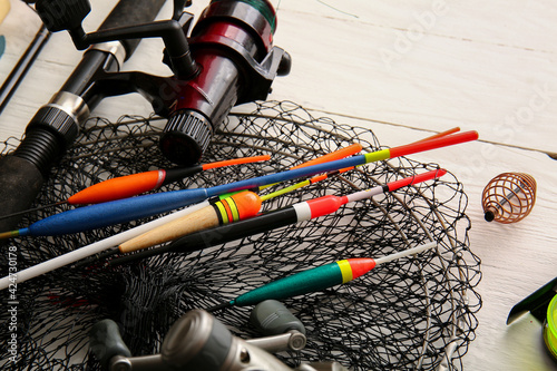 Different fishing equipment on light wooden background, closeup