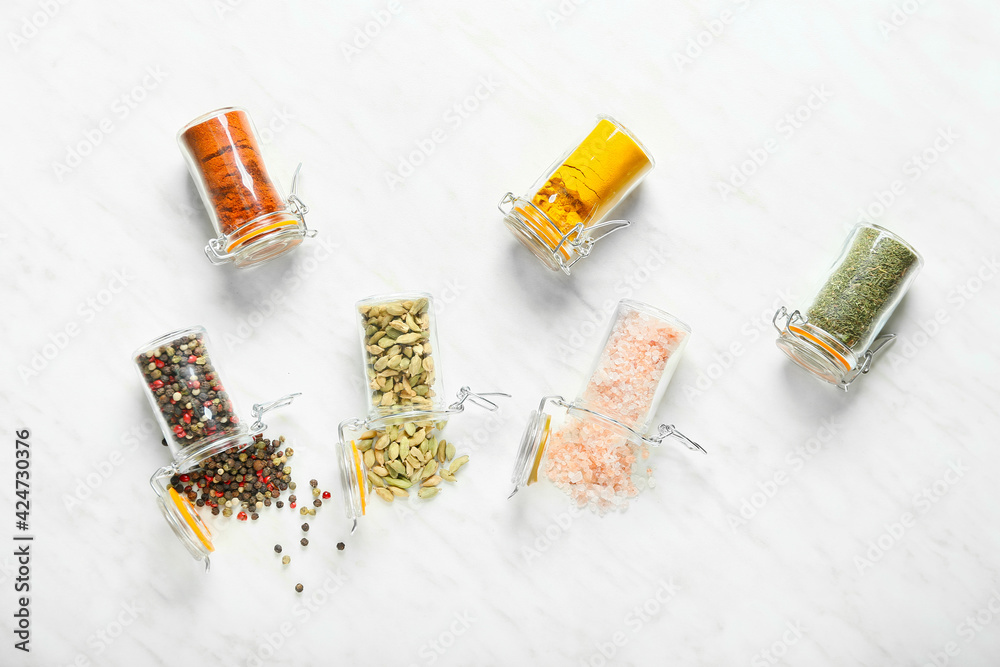 Overturned jars with different spices on white background Overturned jars with different spices on white background