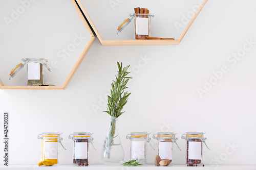 Fototapeta Naklejka Na Ścianę i Meble -  Jars with different spices on shelves in kitchen