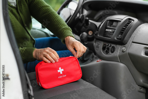 Obraz na płótnie Man with first aid kit in car