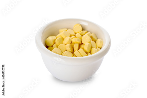 Bowl with folic acid pills on white background