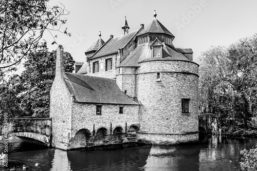 Ezelpoort (Donkey's gate) medieval entry gate surrounded by lake with white swans part of Brugse Vesten (Bruges' City Ramparts) in Bruges, Belgium