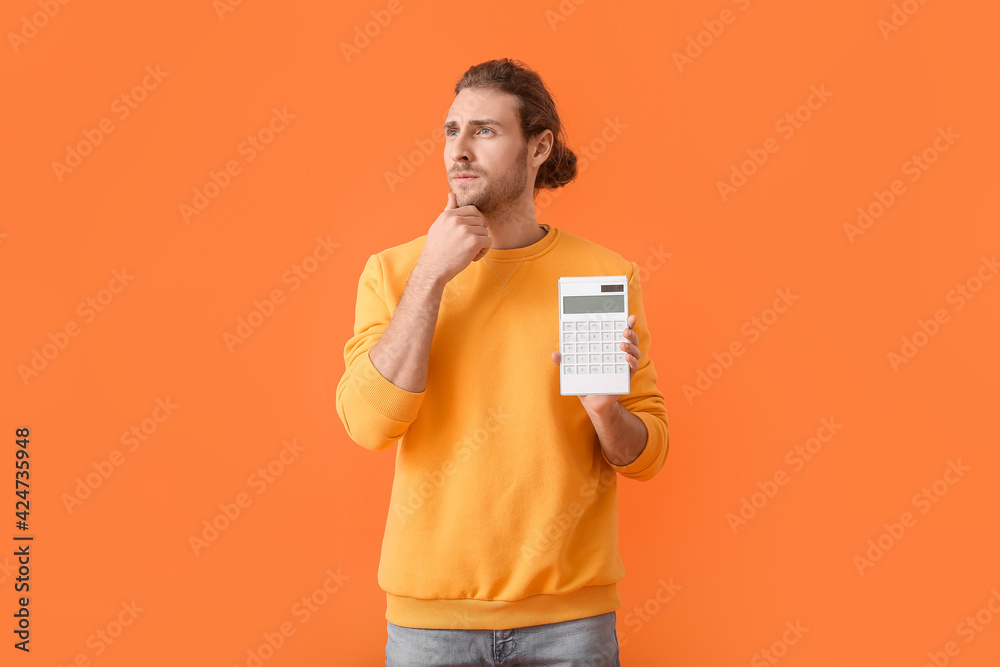 Thoughtful man with calculator on color background - obrazy, fototapety, plakaty 