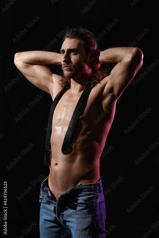 Sexy young man with belt on dark background Sexy young man with belt on dark background