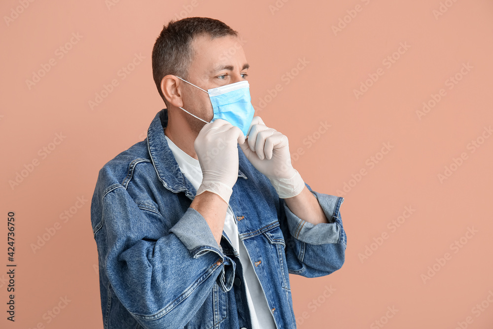 Mature man with medical mask and gloves on color background Mature man with medical mask and gloves on color background