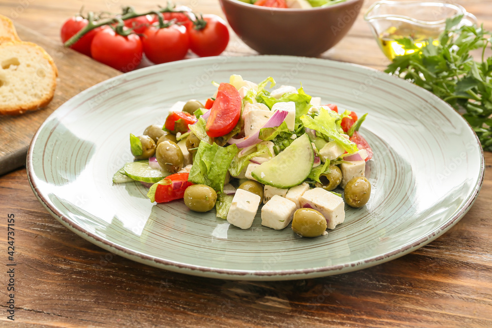 Plate with fresh Greek salad on wooden background, closeup Plate with fresh Greek salad on wooden background, closeup